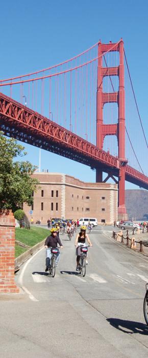 Bike riders on a guided tour departing historic Fort Point underneath the Golden Gate Bridge