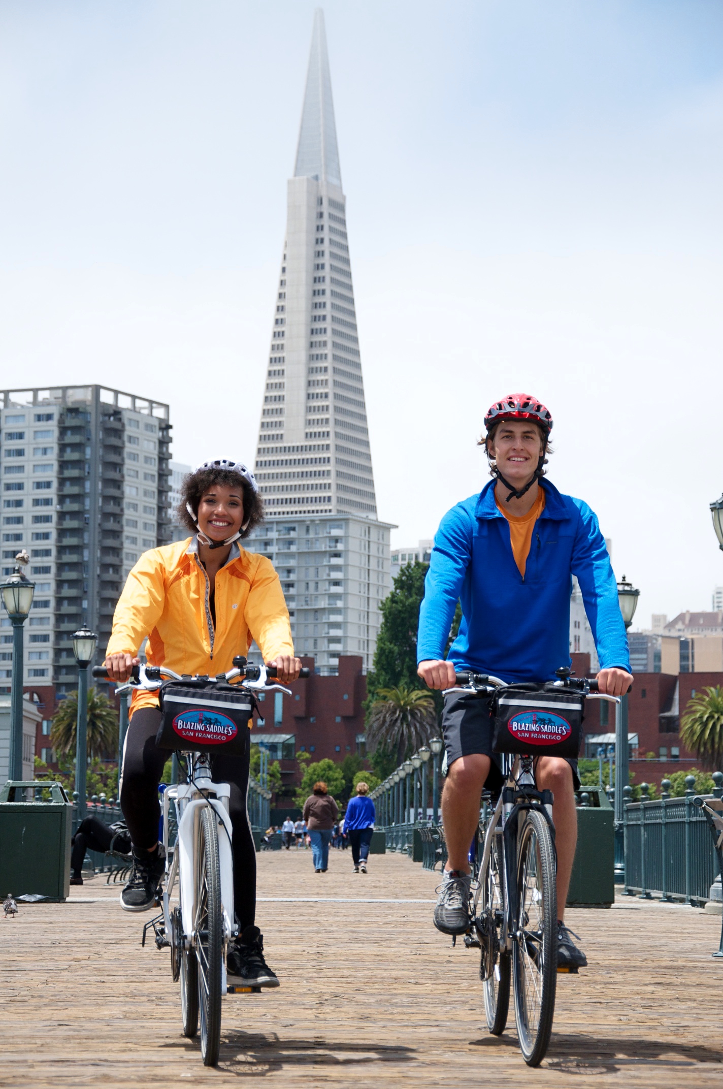 Two bikers in the Embarcadero area, with the Transamerica Pyramid in the background