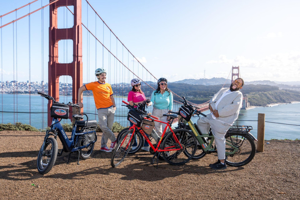 Parents and kids pausing on the Golden Gate Bridge with electric bikes
