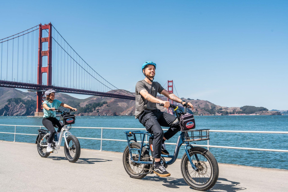 Two bikes parked by the waterfront with San Francisco skyline behind