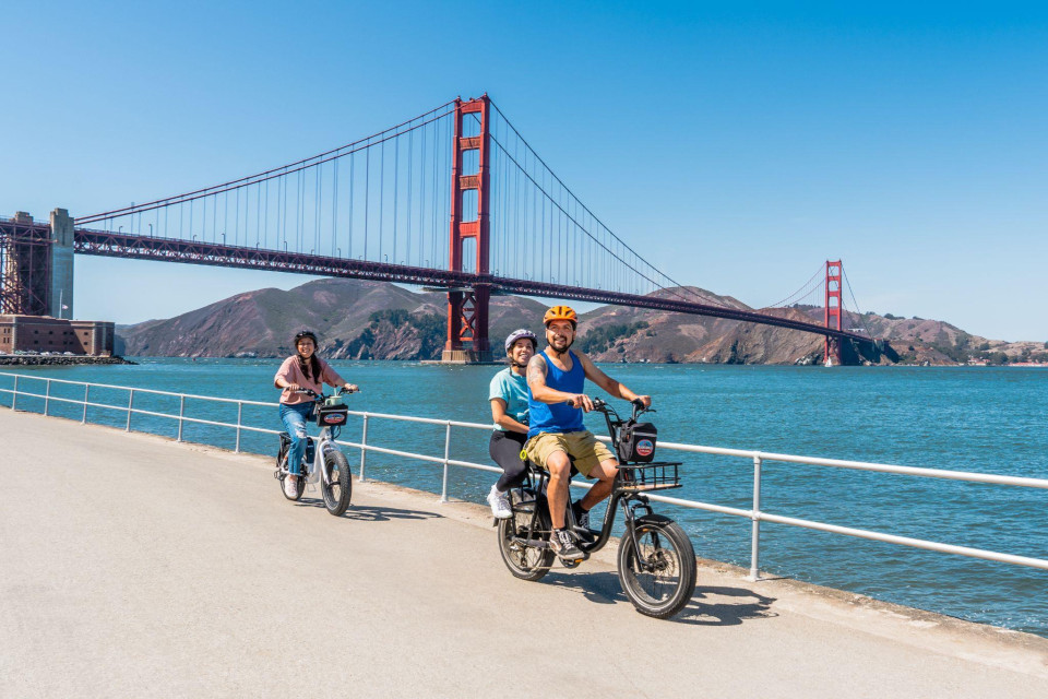 Rider on the bridge path with open water and city views