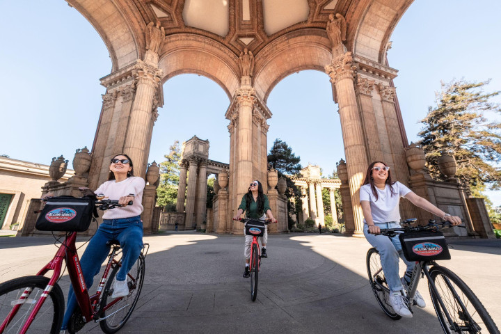 Riders on regular bikes at the Palace of Fine Arts