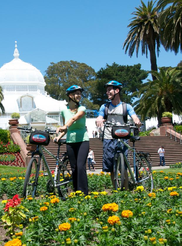 Bikers exploring the gardens in front of the Historic Conservatory of Flowers in Golden Gate Park