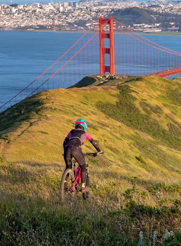 Mountain biker conquering the off-road trails in the Marin Headlands with incredible views of the Golden Gate Bridge and San Francisco