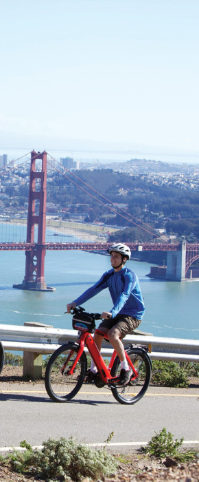 Couple of bikers on Hawk Hill in the Marin Headlands with stunning views of the Golden Gate Bridge and San Francisco